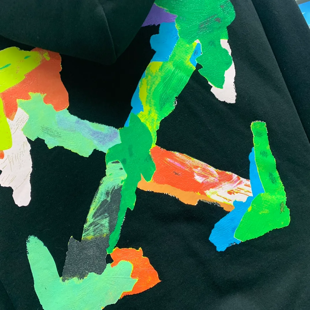 [New] 23SS top tested version environmentally friendly series OFF WHITE OW environmentally friendly ink hand-painted color graffiti pure cotton loose unisex hoodie hooded sweatshirt This printing only took two months to print, the effect is explosive, can directly distinguish the market currency. I won’t introduce much else about this and go directly to the key points. The graffiti part of this printed tree adopts the screen scraping paint graffiti process. The craftsmanship is very realistic, and the foaming treatment on the printing surface is very good, just like the texture of the brush, it is very clear and the texture is smooth. Many versions on the market directly look at the pictures to make the pattern, without worrying about this detail. The color of the front chest is the new slogan of the small size, and the back is also different. The overall printing on our back has the same effect and the same foaming process, which feels very good to the touch and looks very layered! They are all framed by the classic and iconic large warning arrows. The black ones are lake green arrows, with a few white watery patterns added; the white ones are sky blue arrows.  The fabric is made of 460g double-ply double-yarn terry fabric. The fabric feels smooth and has full drape. Size: XS-L P:390